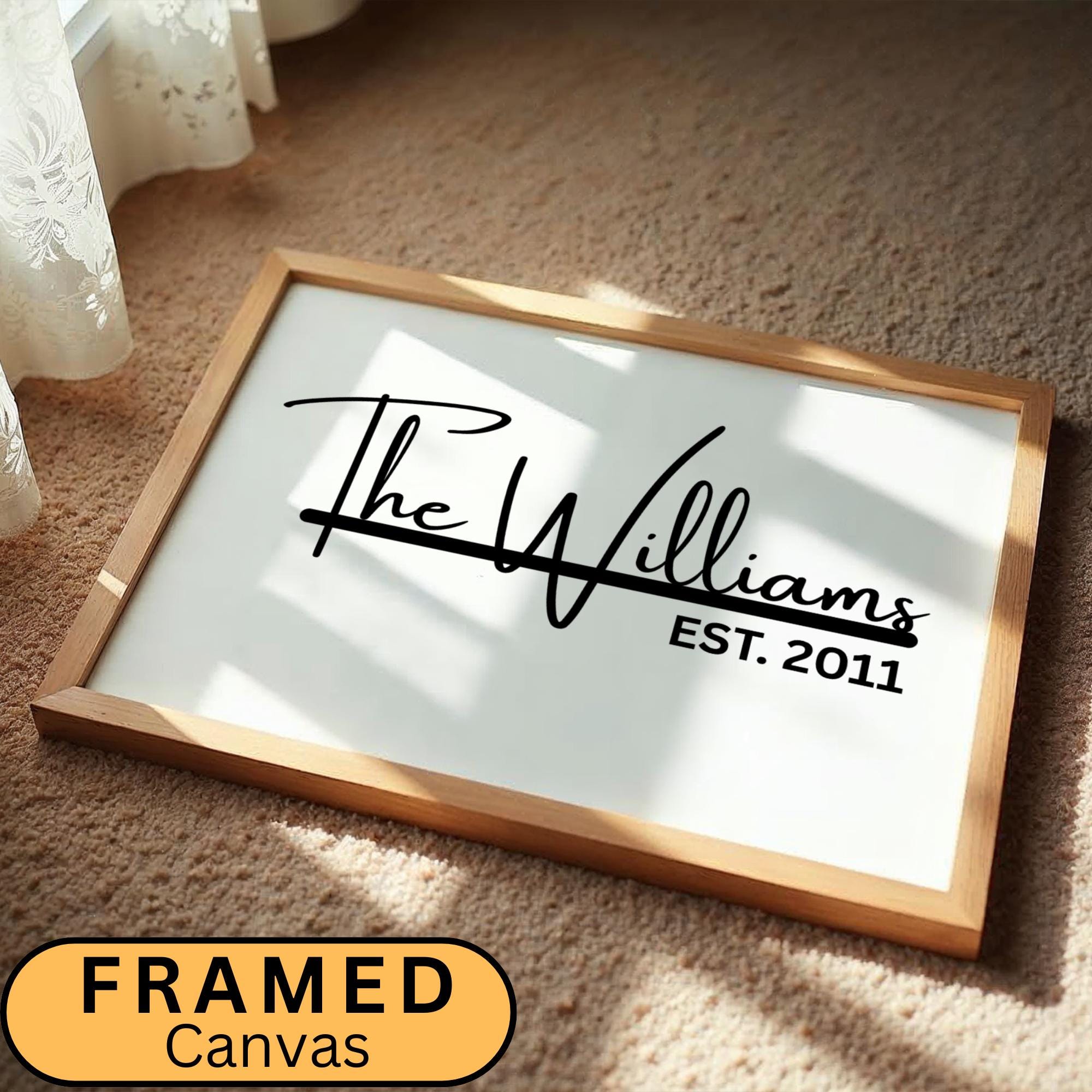 Custom framed canvas sign featuring a personalized family name and the anniversary date in a black and white minimalist style. Elegant wall art decor perfect for farmhouse, modern, or neutral-themed interiors. Ideal for home or office wall display in living rooms, entryways, or workspaces. Thoughtful housewarming, wedding, or anniversary gift idea with a timeless design.